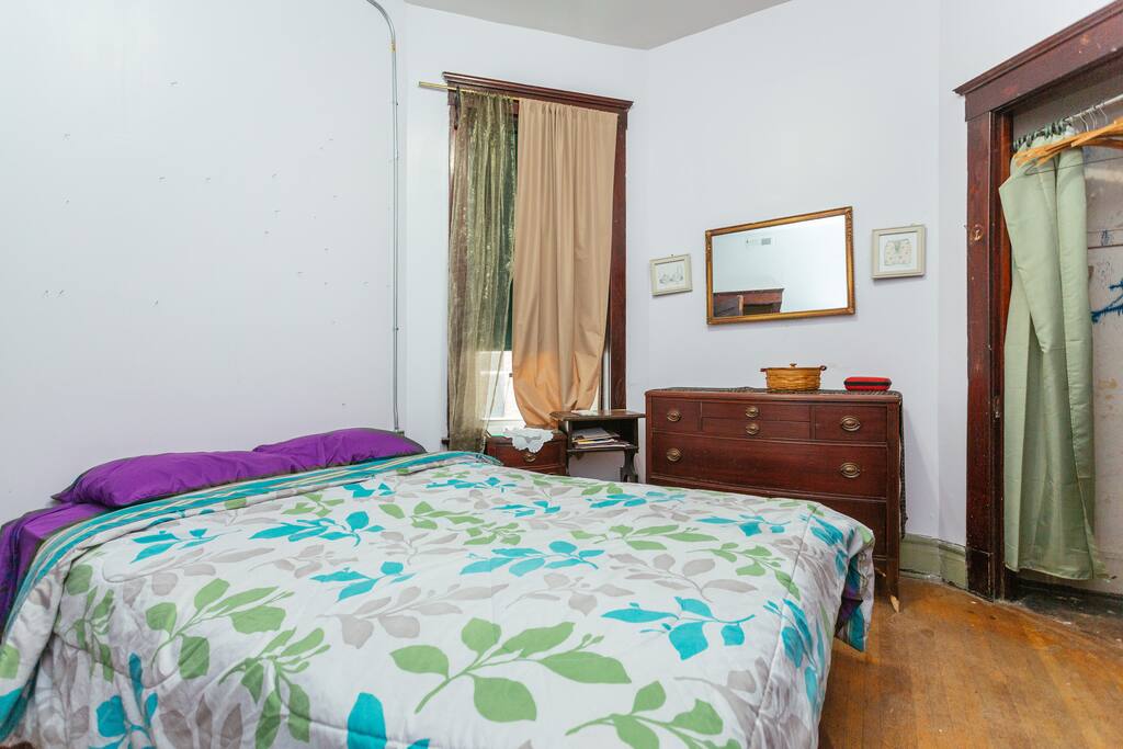 Queen bed with closet and two dressers.