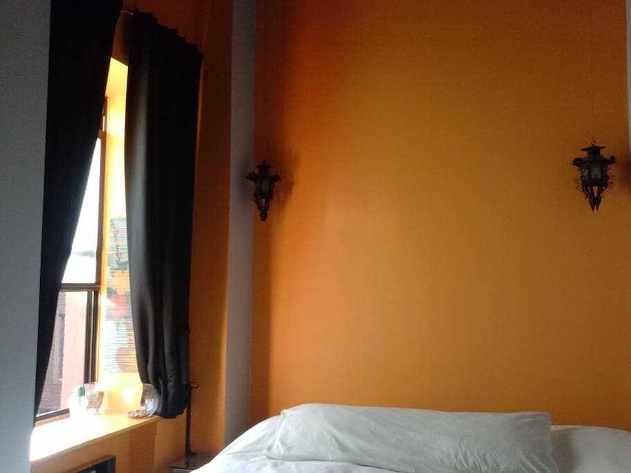 large window w/ air conditioner/ heater on floors; hidden headboard behind bed has microwave heating pad for sore muscles, aromatherapy spray, small book light, speakers; hanging candle holders look gorgeous at night!