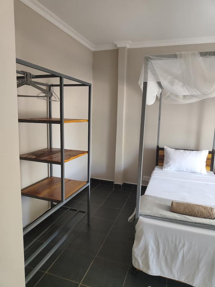 Room 2 has two single beds, shelves and fan. The facilities are shared.
