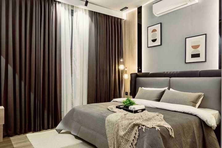 ภายในห้องนอนสีเทาสวยงามพร้อมม่านสองชั้นเพื่อบังแสงแดด