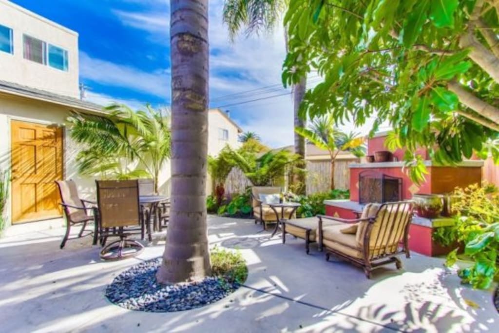 The back cottage patio with fireplace and tropical lounging area