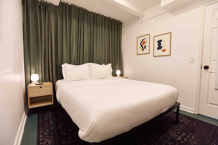 Quarto. Tufo queen e cama com agulha. Janela atrás da parede de cortinas e janela para o lado da cama. Smart TV.