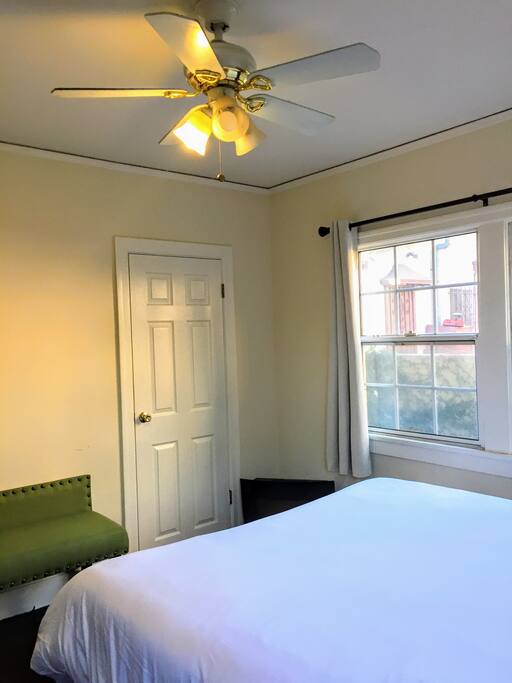 Bedroom as you get in with a walk in closet by the window & ceiling fan