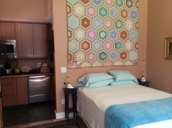 A queen size bed offers comfort for 2. A kitchenette with microwave, bar refrigerator, single induction cooktop, and copper sink permit light eating in the cottage.   The bathroom, with tub/shower and toilet, are behind the quilt wall.