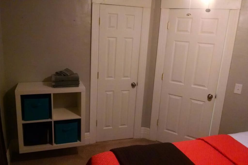 Space to store your things - empty cubby unit on the left, adjacent to a closet. Door on the right is the entrance to the bedroom.