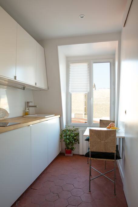 Equipped kitchen with three people sitting