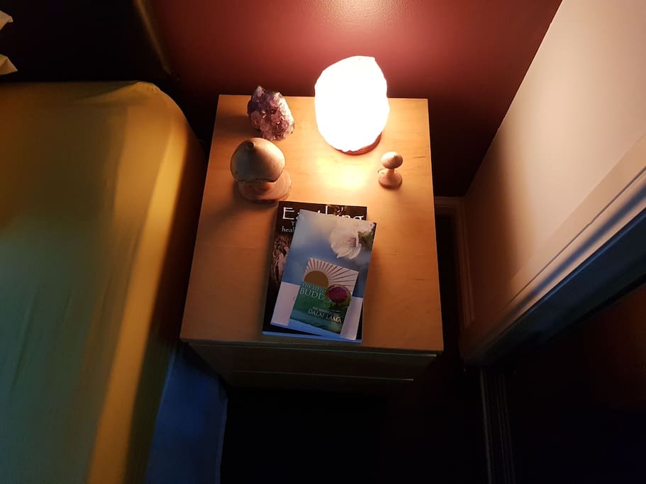 Himalayan Salt Lamp and crystals beside bed