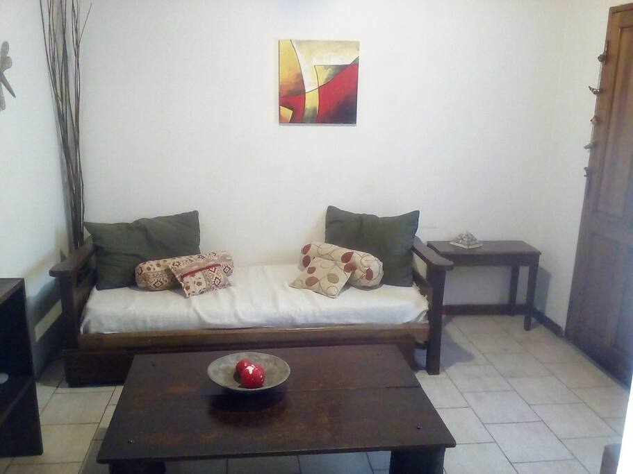 Sala de estar con sillón cama y televisión