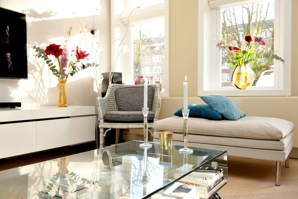 Large bright living room with electric fireplace and open kitchen