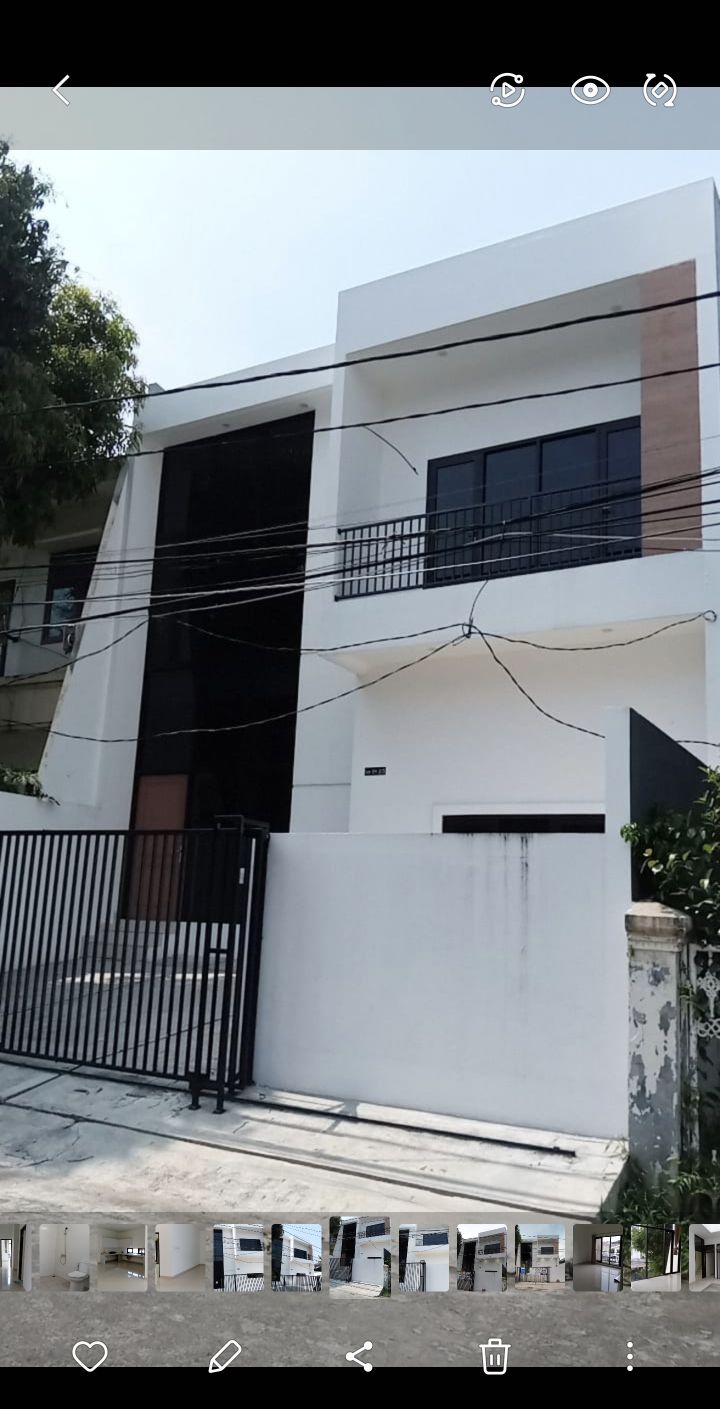 A contemporary two-story house features a sleek exterior with a mix of white and dark elements. The facade includes large windows and a prominent entrance, framed by a modern gate and minimal landscaping.
