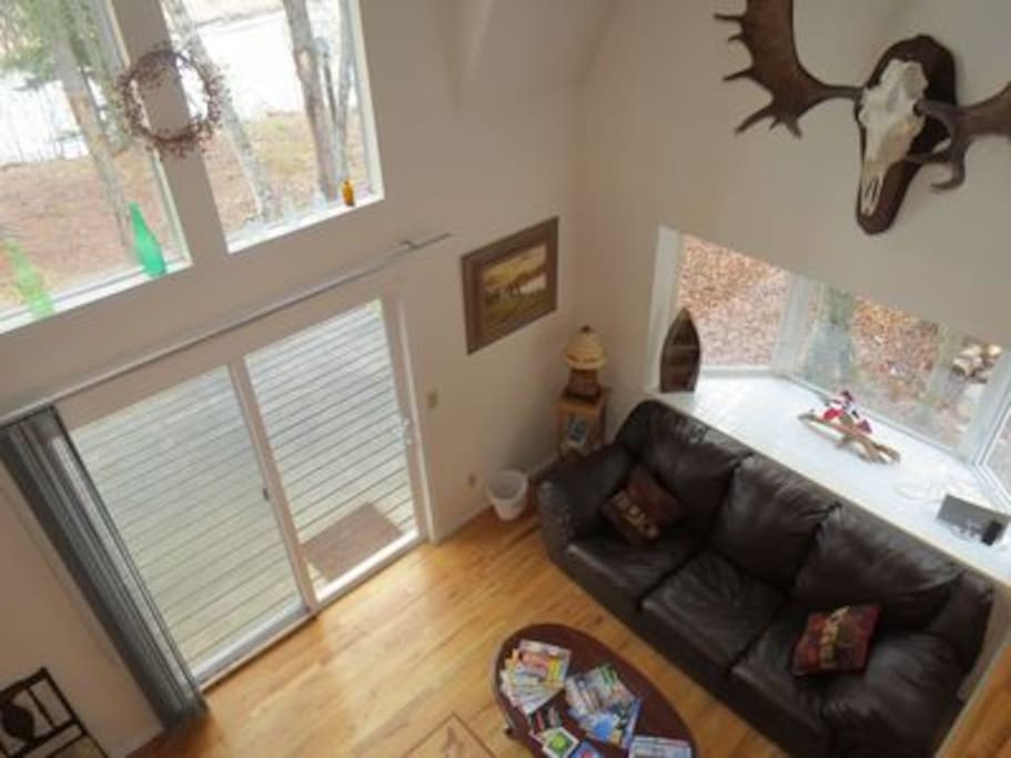 Spacious living room with cathedral ceilings, decorated with Alaskan decor, matched with stunning views of the Kasilof River right out your back door.