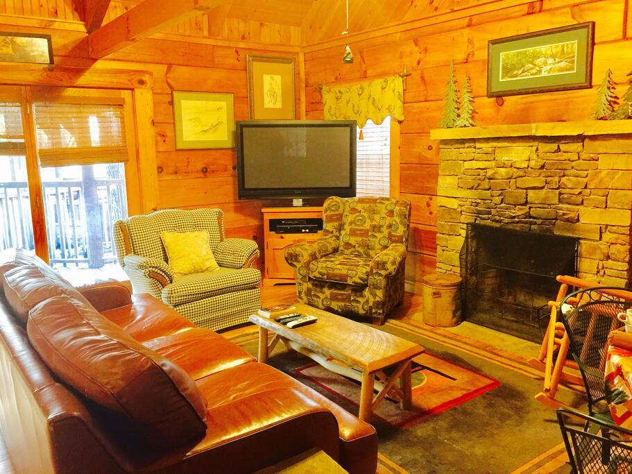 Comfy leather couch and easy chairs by living room fireplace. You can see the glow of the fire from your loft suite