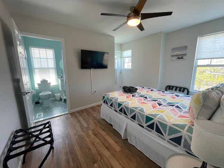 First Bedroom featuring Queen Sized Bed, Private Full Bathroom, & Smart TV