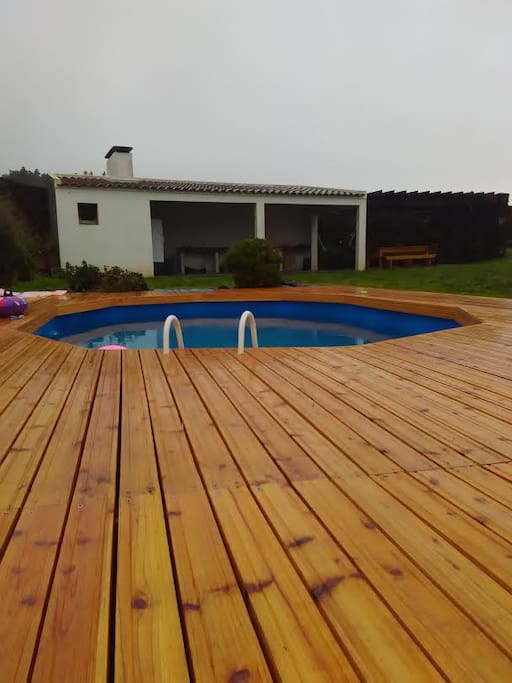 Piscina com churrasqueira ao fundo.