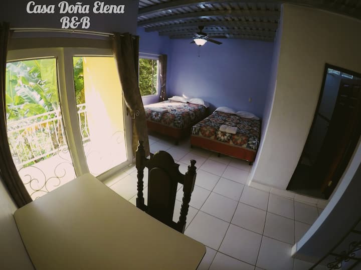 Tavolinë pune, derë xhami rrëshqitëse për në ballkon. Dhomë gjumi me 2 krevate dopio, dritare panoramike, ventilator tavani. Dera e banjës (djathtas). Dollapi në të majtë të tavolinës (nuk tregohet në foto)