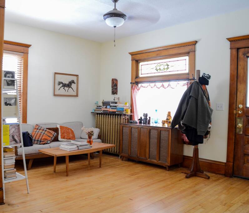 Living room with console stereo, lots of woodwork and stained glass