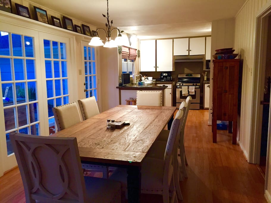 Dining room with large teak table overlooking pool.