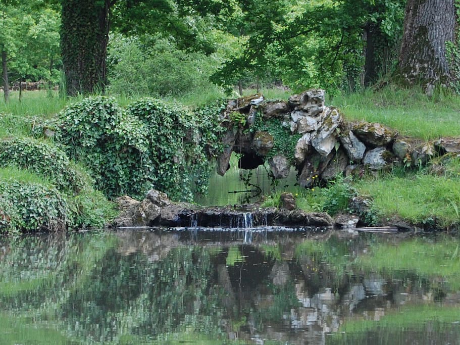 Waterfall over the pond in the meadow. Cascade au dessus du lac dans le parc.