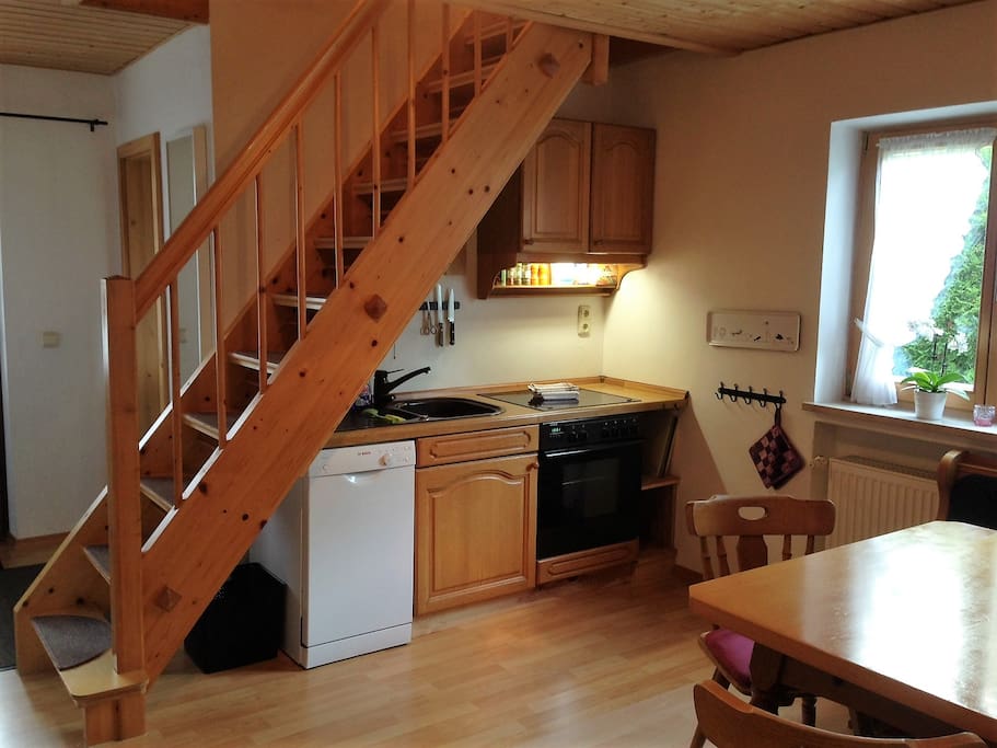 Küche mit Spülmaschine und Backofen; Treppe zum Schlafzimmer oben; hinter der Küche liegt das Bad.