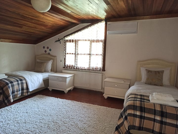 Unser Zimmer mit 2 Einzelbetten im Obergeschoss. Es gibt einen Einbauschrank und Klimaanlage. Blick auf den Vorgarten.