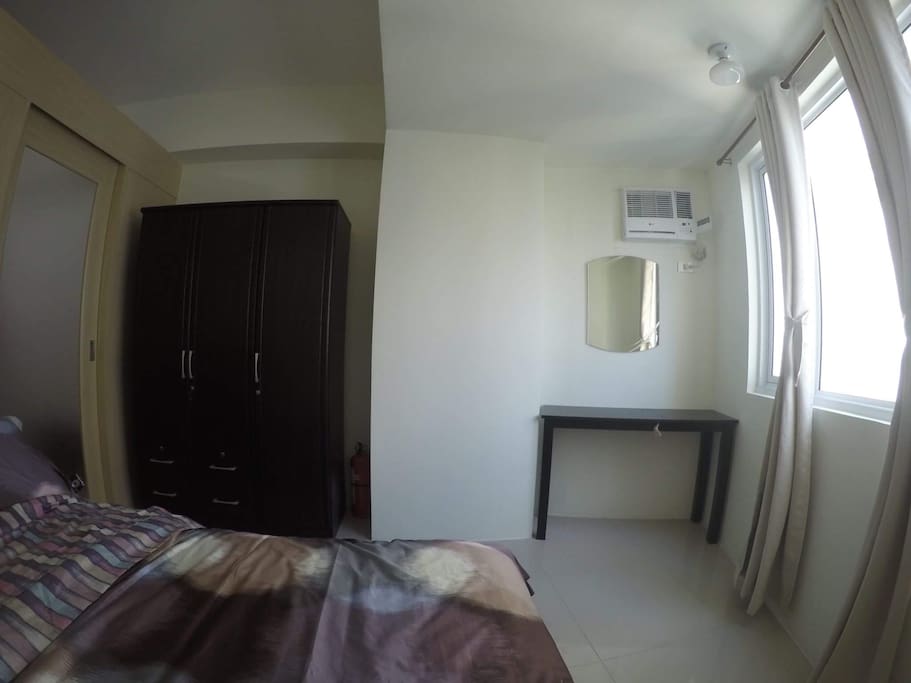 spacious bedroom with a large closet and a very comfortable queen size bed in a fitted sheets, linens and comforters