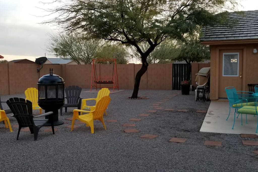 Back yard. Fire Pit. Swing. patio table with chairs. Grill.