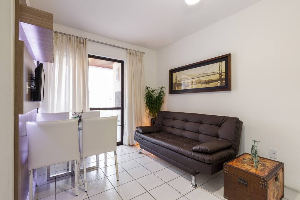 Sala de estar com sofá cama, TV a cabo e ventilador de teto