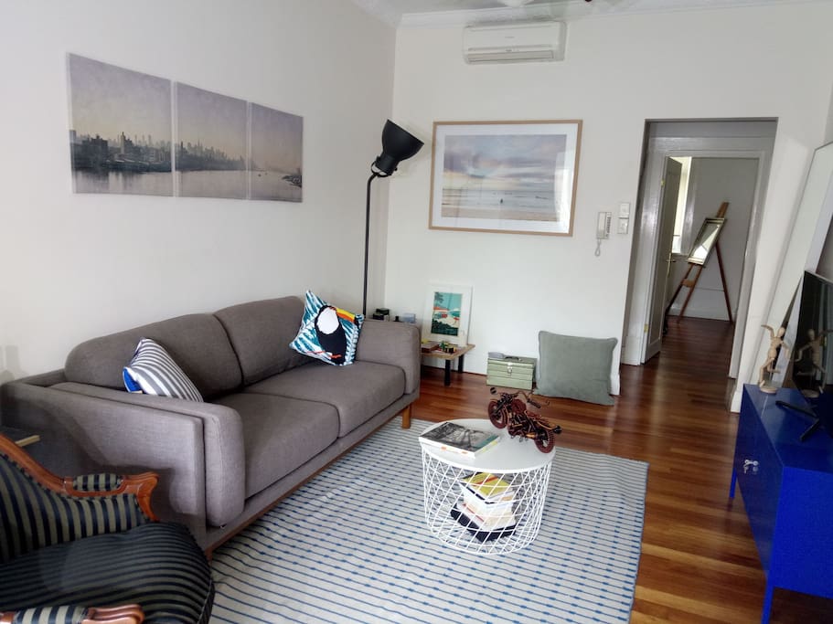 Bright living room, super comfy sofa from West Elm, design / architecture books to read, travel info on Sydney, A/C and ceiling fan, artwork on the walls,
