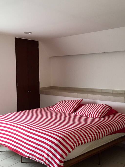 Confortable king size bed, with closet and two chairs
with table.