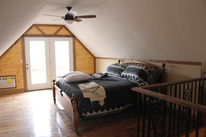 Upstairs bedroom, king bed with private bath and balcony access.