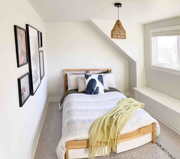 غرفة نوم علوية بسرير مزدوج ومكتب مع كرسي. 