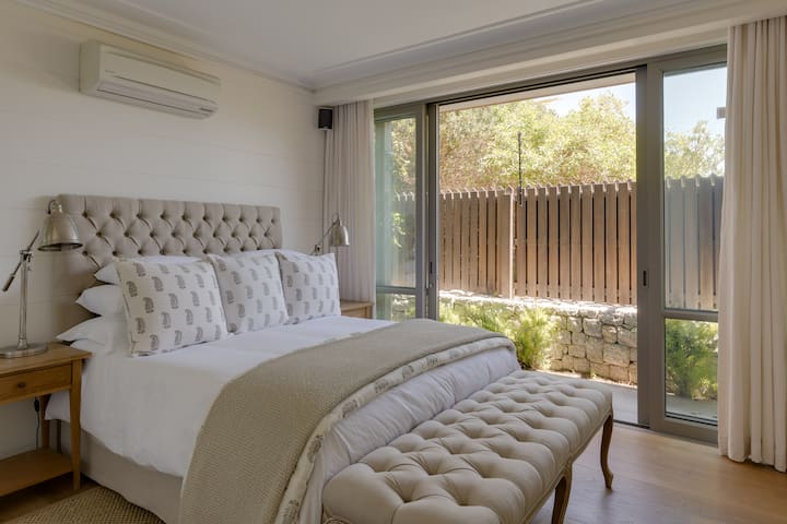 Spavaća soba 1: bračni krevet (širine 150 – 179 cm), klima-uređaj/grijač, klizna vrata koja vode do malog vrta, privatna kupaonica s tuš-kadom u ravnini poda