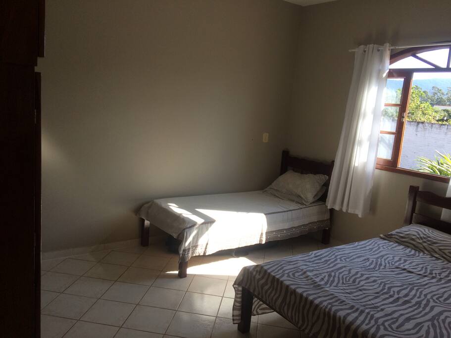 Quarto com uma cama de casal, outra de solteiro e com possibilidade de colocar colchão. Com armário