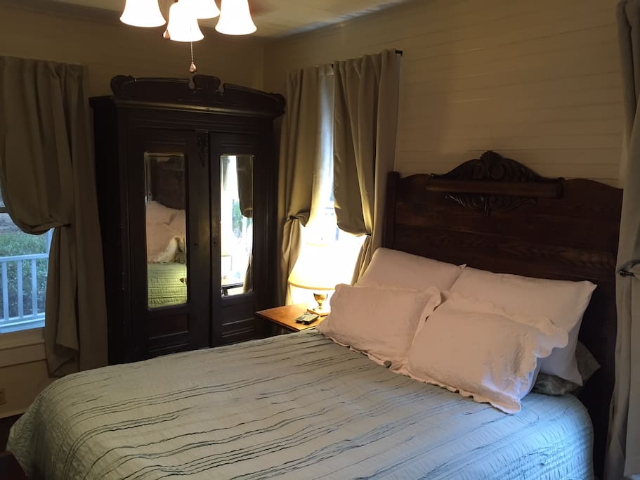 Queen Size bed nestled among antiques in the very cozy bedroom