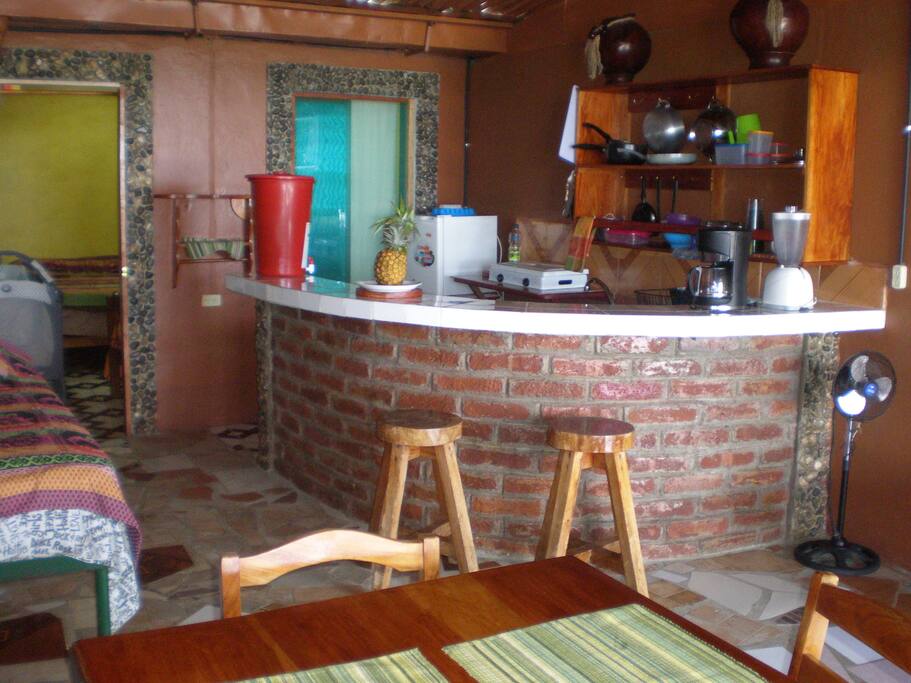 Full kitchen sink, kitchenware, blender, coffeemaker, gas stove top, small refrigerator/freezer and filtered mineral spring water.