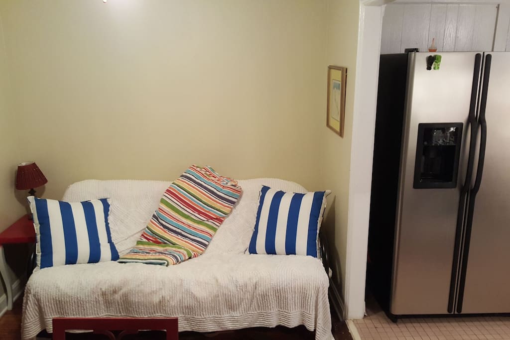 Futon adjacent to kitchen folds down into another bed.
