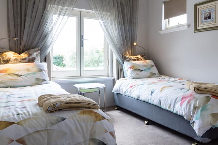 Dhoma e gjumit e dytë me hapësirë bujare midis krevateve 