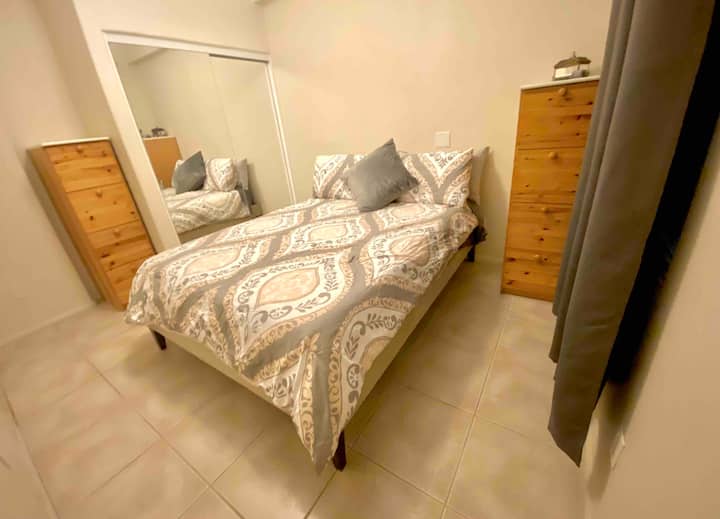 Dormitorio de invitados. Cama tamaño queen. Espacio en el cajón. Espacio en el armario. Vista de la entrada principal.