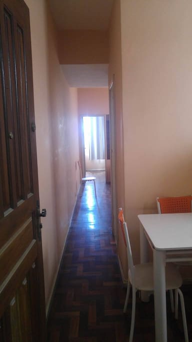 Entrada, com área para mesa e geladeira à direita
