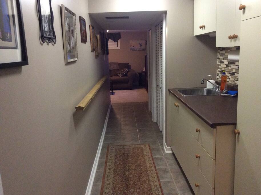Hallway with small kitchen leading to living area