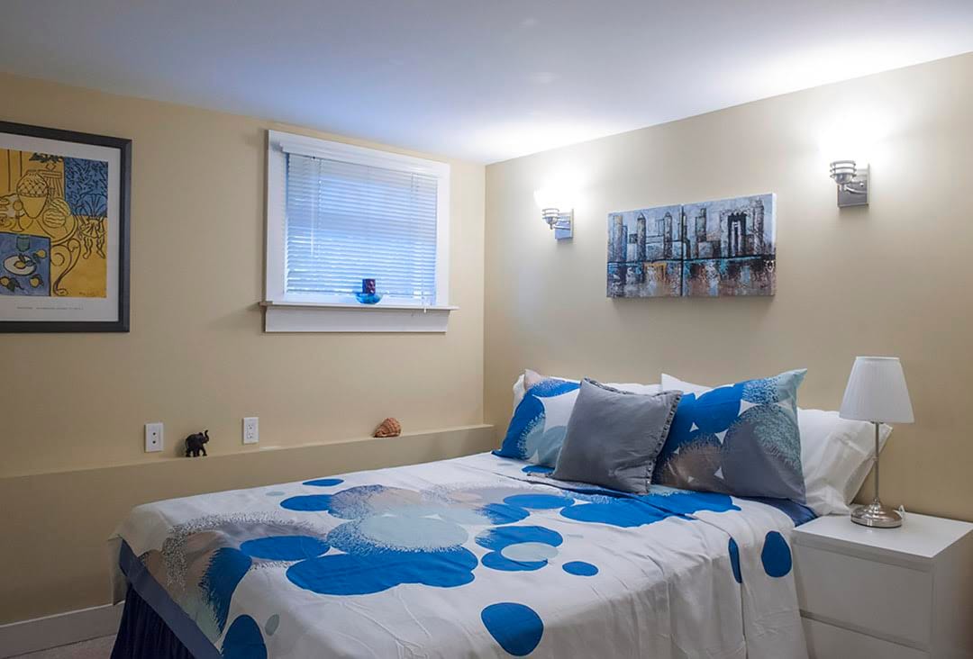 卧室温馨、装饰精良，配有两个床头柜、一个抽屉和一个巨大的衣柜。