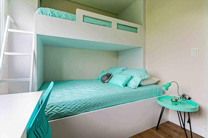 غرفة حديثة وعملية مع سرير بطابقين مخطط له وسرير مزدوج في الأسفل وسرير فردي في الأعلى. تجلب لوحة الألوان في ظلال المياه الخضراء الخفة والنضارة، وهي مثالية لبيئة شابة ومريحة وتتمتع بها بشكل جيد.