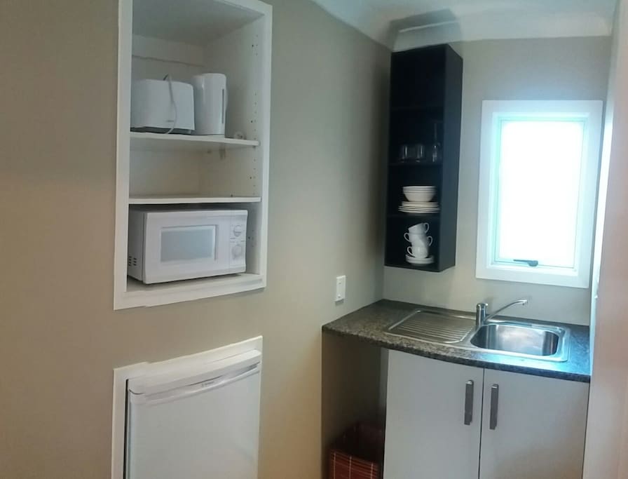 Kitchenette. (small bench, sink, fridge, microwave, jug, toaster, hotplate).