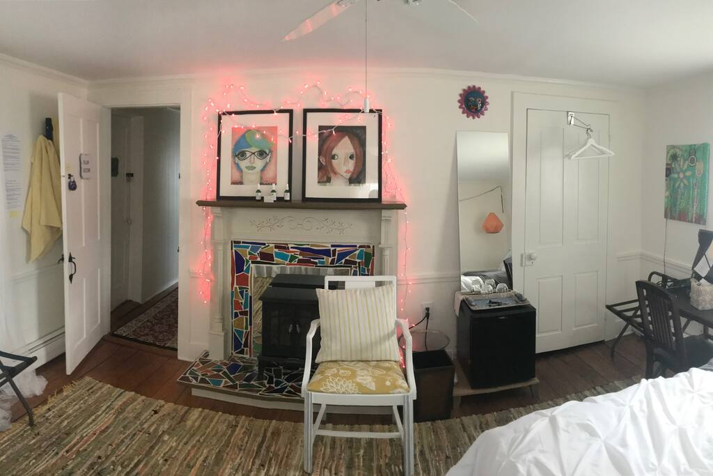 The electric fireplace adds warmth and added coziness to the room if needed. The fairy lights around the fireplace are on a timer, or you can just turn them off. Next to the fireplace is a small refrigerator.