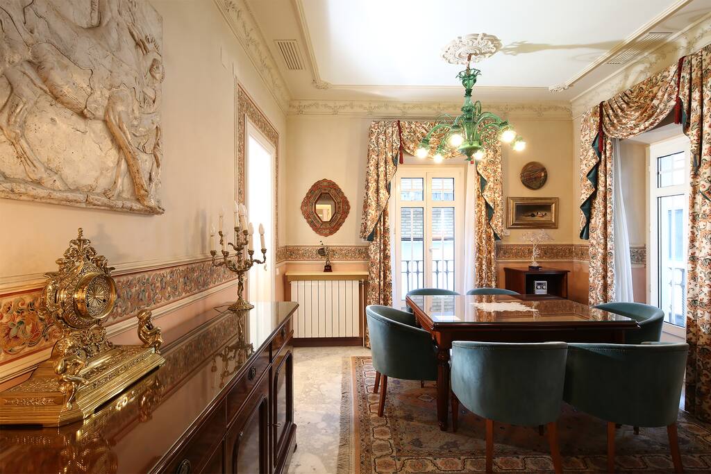 The living-dining area is decorated with dark wood furniture and original artwork.