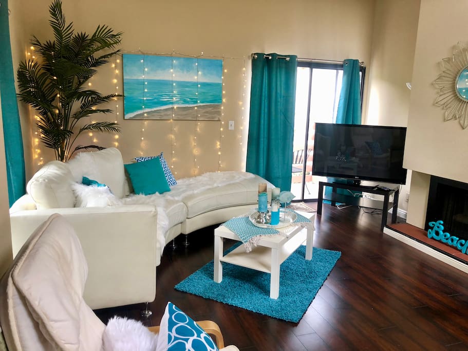 We updated the brown sofa sectional for a fresh white semi circle sofa and an aqua colored beach theme in living room. Sliding glass doors open to 2 seperate balconies.