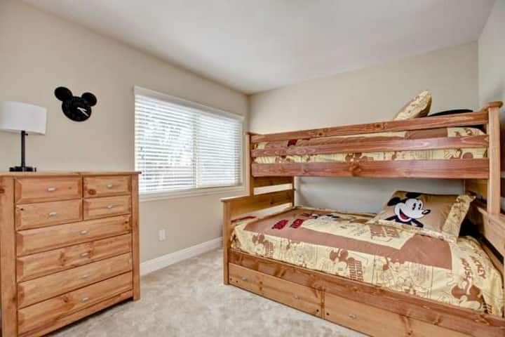 חדר שינה שלישי מציע מיטה זוגית מלאה עם מיטה זוגית נוספת.