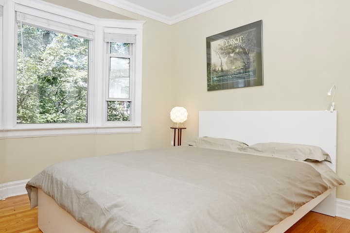 Спалнята има голям прозорец на залива, вентилатор на тавана, светлини за четене.