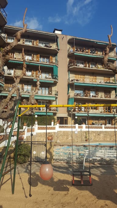 Vista meridional dels apartements amb parc infantil i piscines.