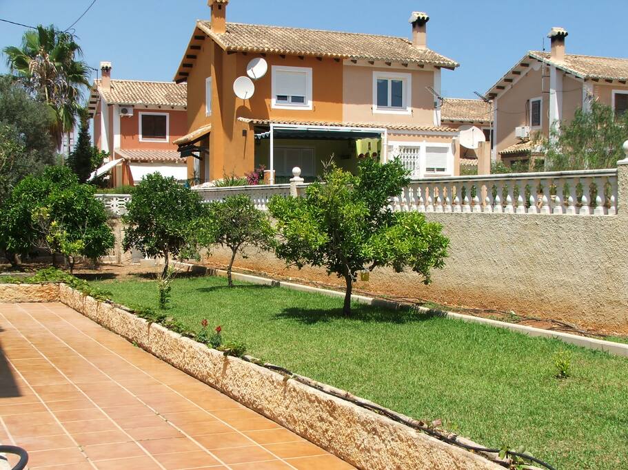 Zona norte del jardín: terraza que permite reuniones, comidas, juegos...y césped con naranjos